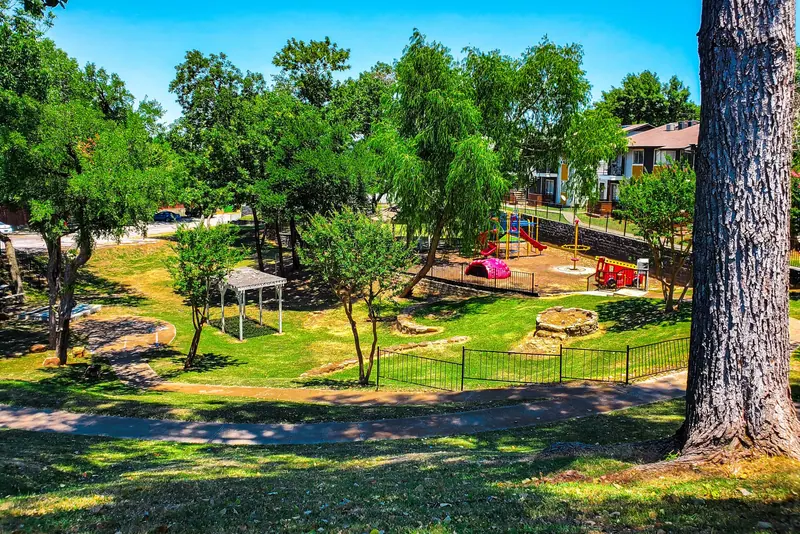 A walking path beside a green community park